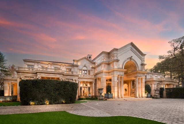 Ultra-luxury mansion at dusk, positioned to the right of frame